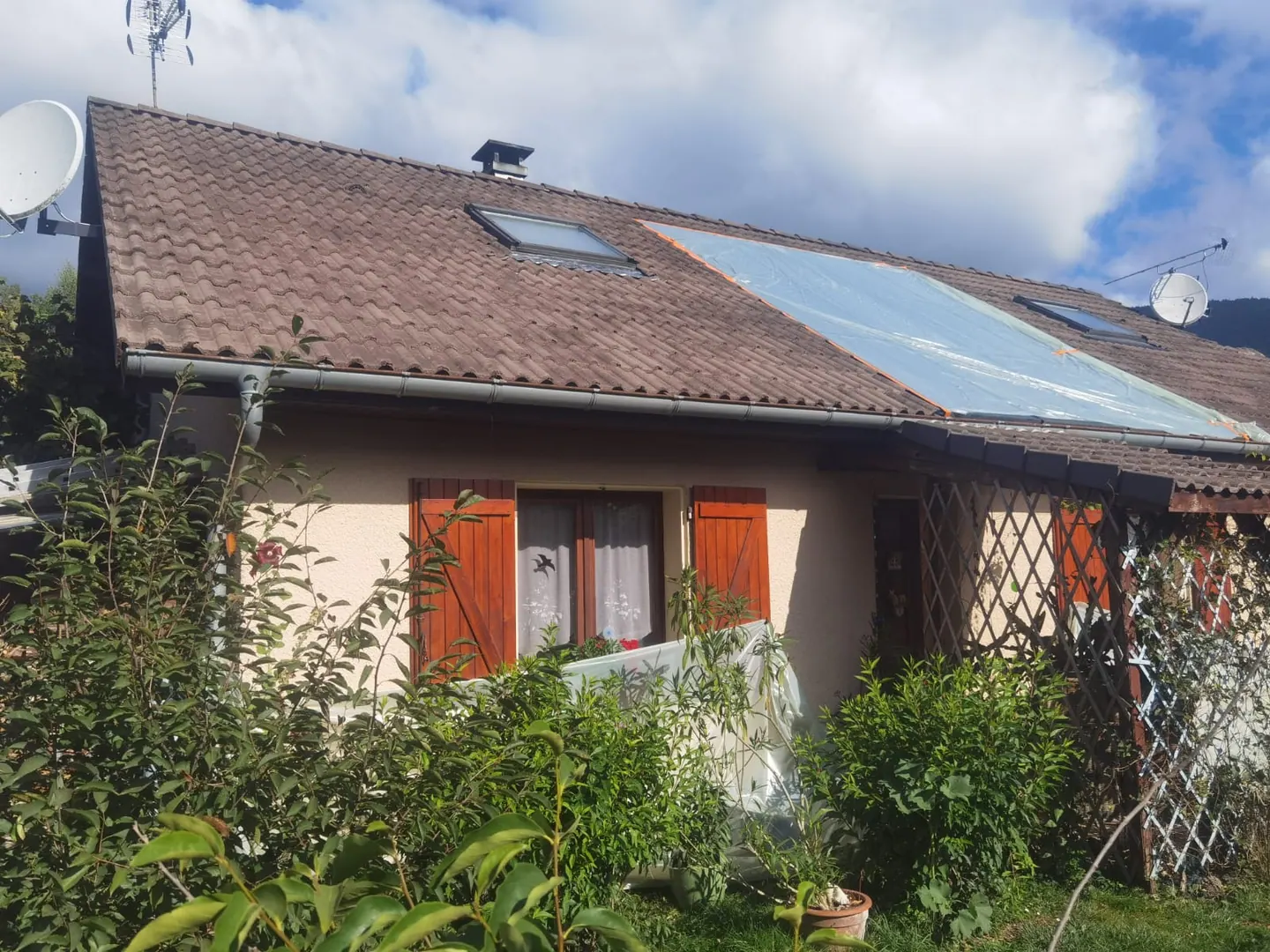 Toiture en tuiles avec panneaux solaires et traces visibles sur la couverture